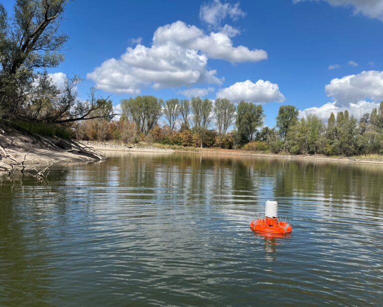 Das Bild zeigt die orangene schwimmende Klimamessstation im Wilhelmswörthweiher